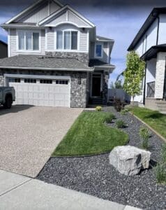 New Look Landscapes Calgary - Project Photos - New Build Home Front Yard - New sod, stone garden bed, trees and plants